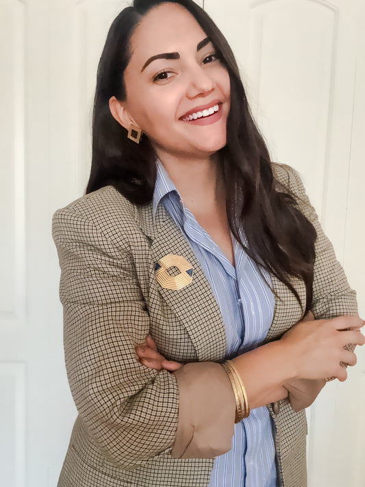 Gold geometric brooch and earrings styled with a vintage blazer and striped blouse. 